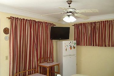 Detalle de una habitacion con el televisor y frigorifico, ambas similares