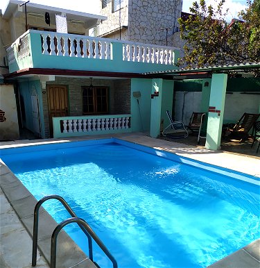 Merendero al lado de la alberca (piscina).Al fondo una de las habitaciones que se alquilan 