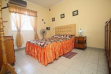 Habitacion con aire acondicionado y una cama matrimonial y otra personal